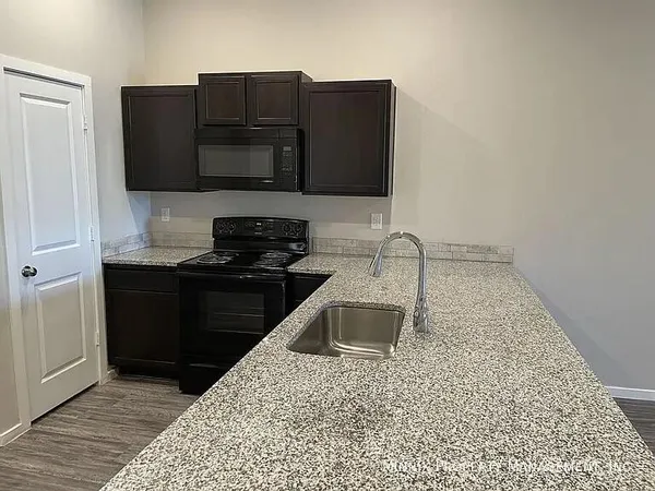 a kitchen with granite countertop a refrigerator and a stove