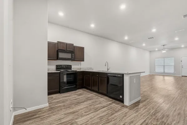 a bathroom with a granite countertop toilet a sink a mirror a bathtub and shower