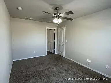 an empty room with a fan and a fan