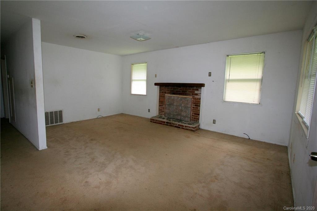 1400 Pleasant Plains Road Matthews, NC 28105 - Photo 17 of 31 an empty room with a fireplace and windows