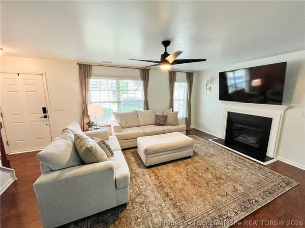 a living room with furniture a flat screen tv and a fireplace