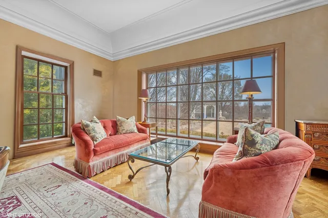 a dining room with furniture a chandelier and wooden floor