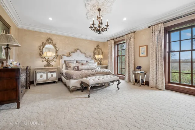 a spacious bedroom with a bed a mirror and lamp