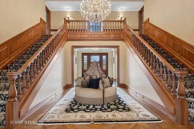 a living room with furniture a chandelier and a fireplace