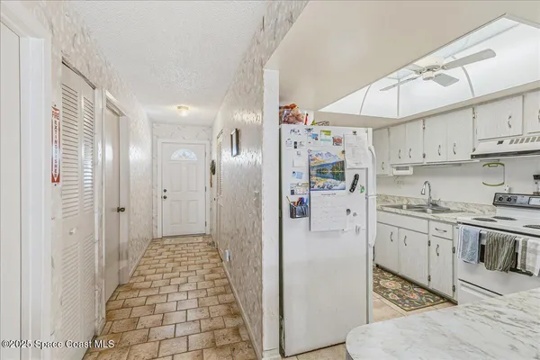 a kitchen with stainless steel appliances granite countertop a refrigerator and white cabinets
