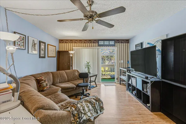 a living room with furniture flat screen tv and a large window