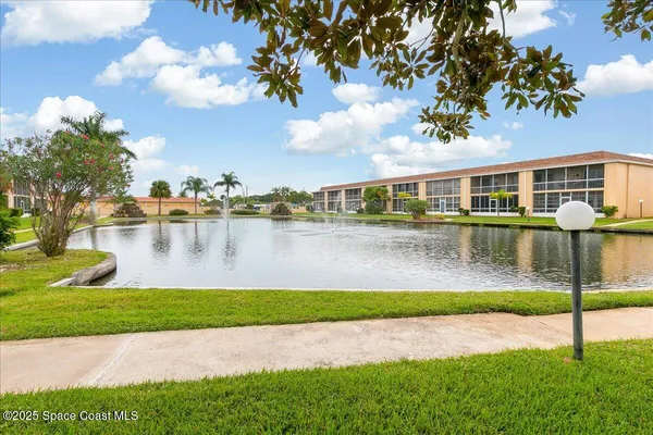a view of a house with a yard and a fountain