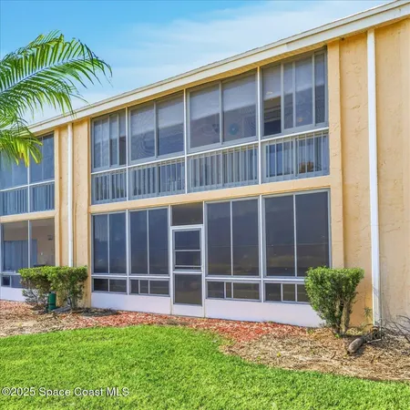 a front view of a house with a yard and potted plants