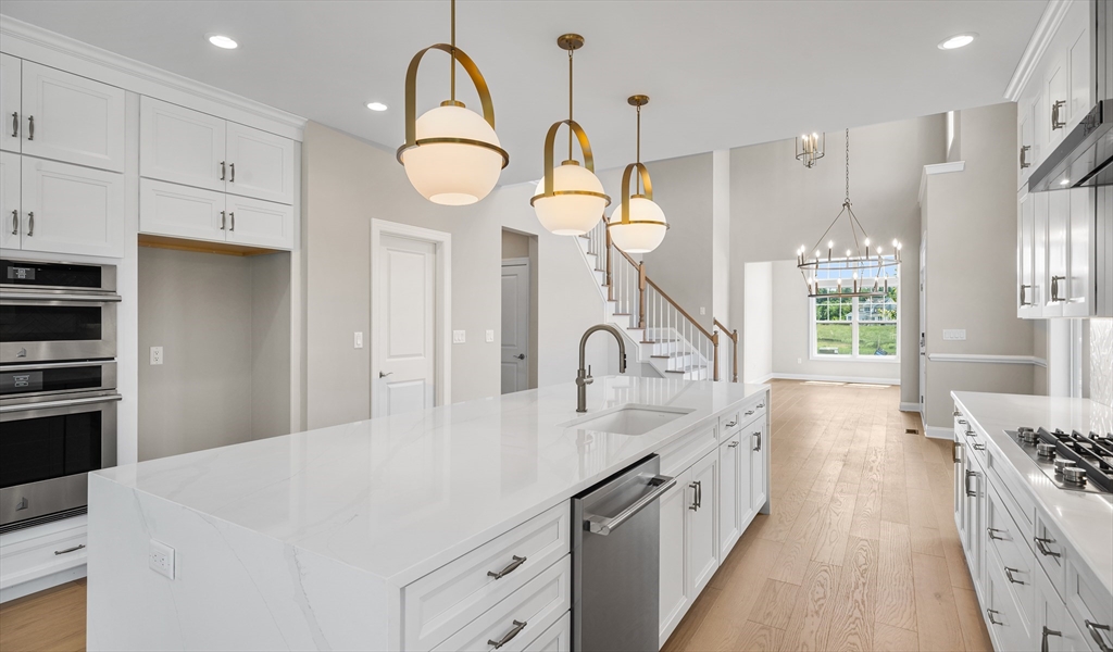 35 Ingalls Vlg Way, Unit 60 Boxford, MA 01921 - Photo 1 of 3 a large kitchen with stainless steel appliances a large center island attached withe living room