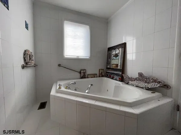 a bathroom with a tub sink and mirror