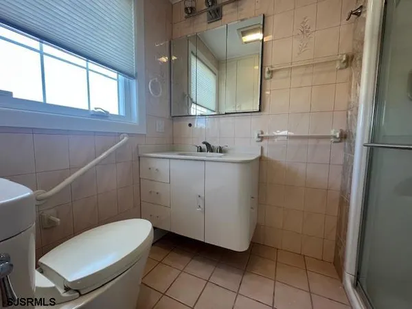 a bathroom with a granite countertop toilet sink and mirror