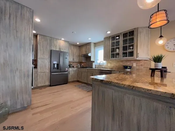 a kitchen with stainless steel appliances granite countertop a sink refrigerator and cabinets