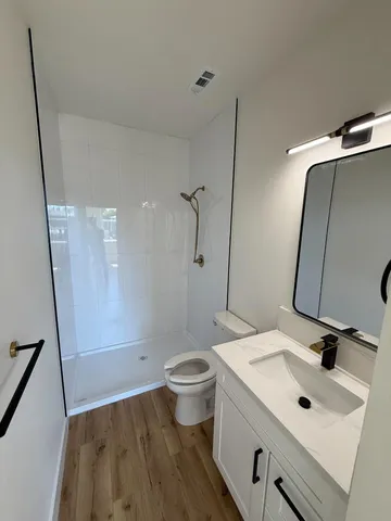 a bathroom with a sink a toilet and shower