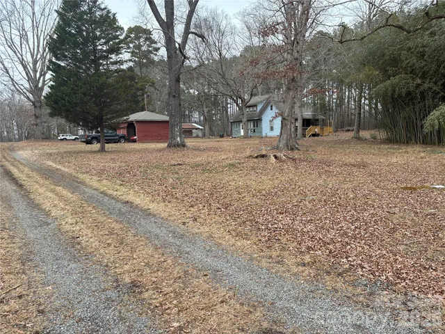 a view of a house with a yard and wooden fence