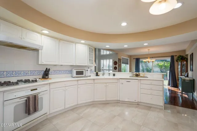 a kitchen with white cabinets and white appliances