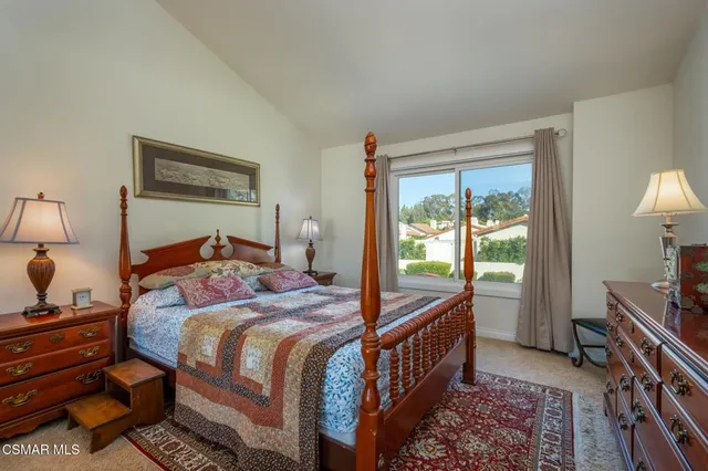 a bedroom with a bed and a dresser next to a window