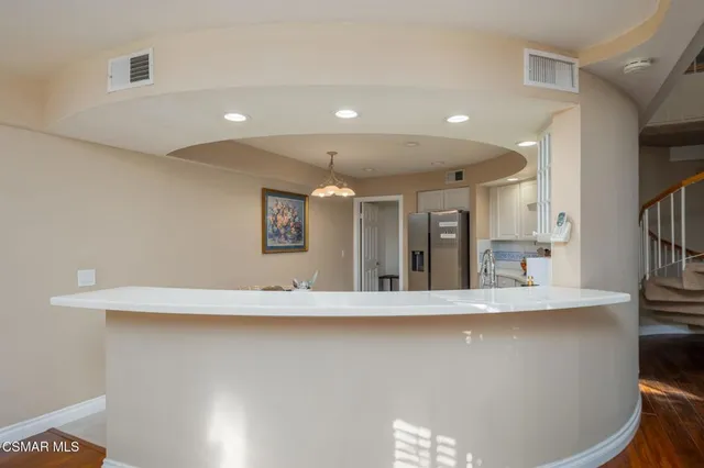 a large kitchen with kitchen island a large counter top space and stainless steel appliances
