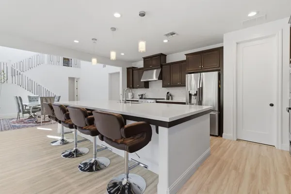 a living room with furniture a flat screen tv and kitchen view