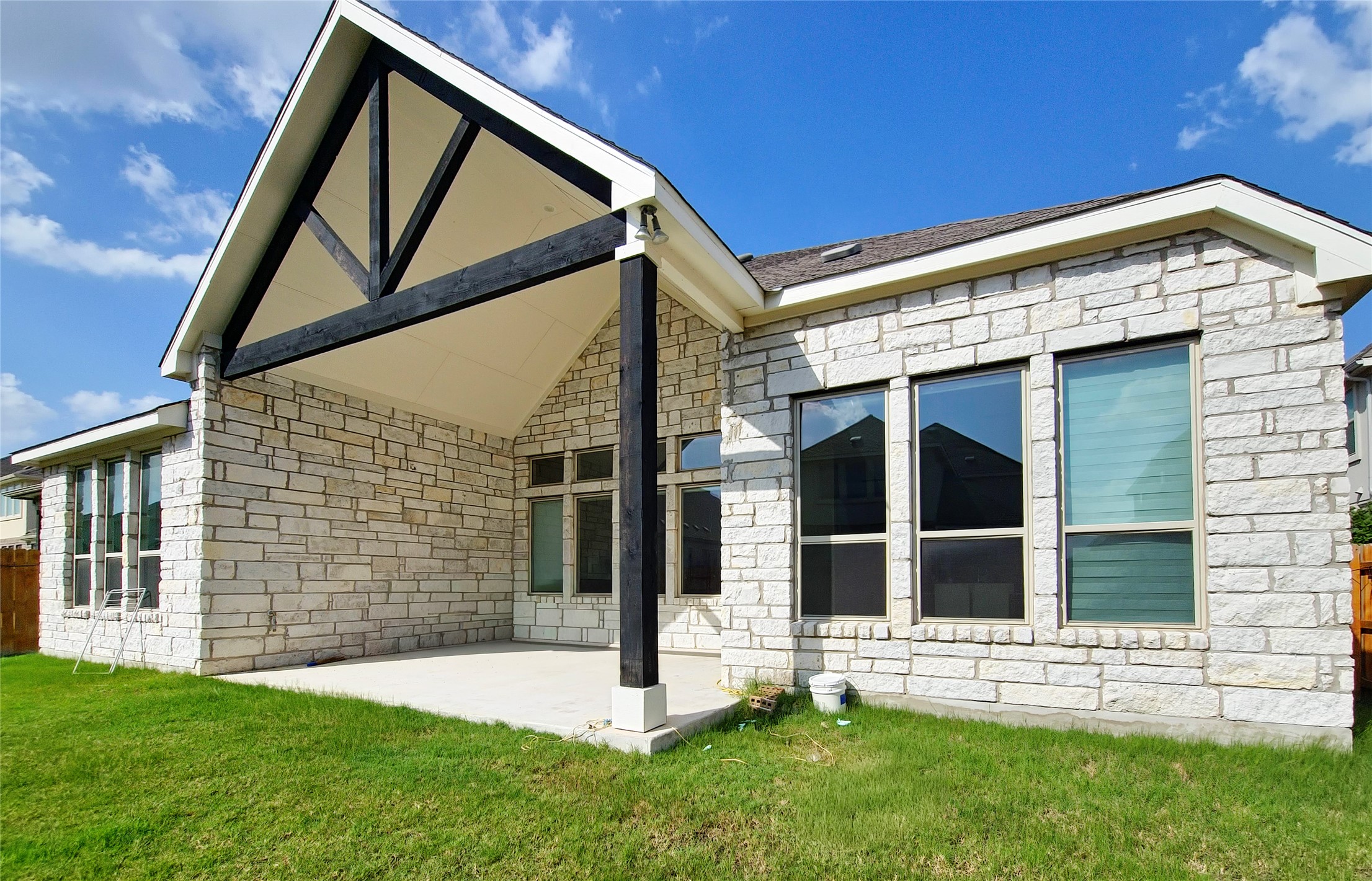813 Sunny Ridge Drive Leander, TX 78641 - Photo 31 of 32 A spacious covered patio invites outdoor enjoyment with a striking vaulted ceiling and exposed beams.