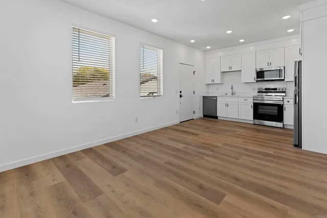 a large kitchen with stainless steel appliances granite countertop a stove a sink and a refrigerator