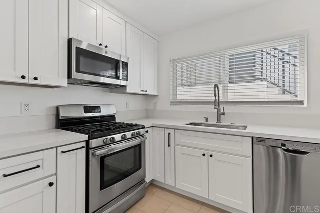 a kitchen with white cabinets and appliances