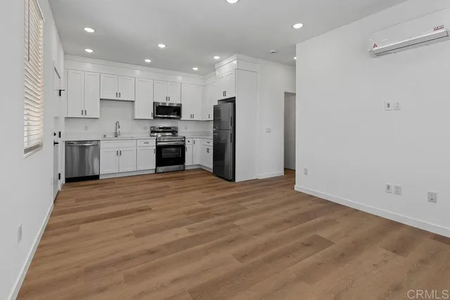 a large kitchen with stainless steel appliances granite countertop a stove a sink and a refrigerator