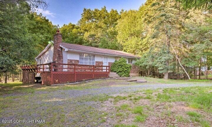 a view of a house with a big yard and large trees