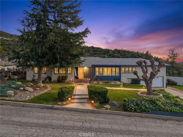 a front view of a house with a garden and plants