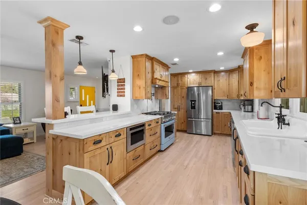 a large kitchen with stainless steel appliances lots of counter space and a sink