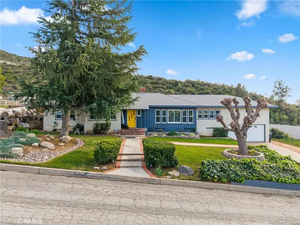 a front view of a house with a garden