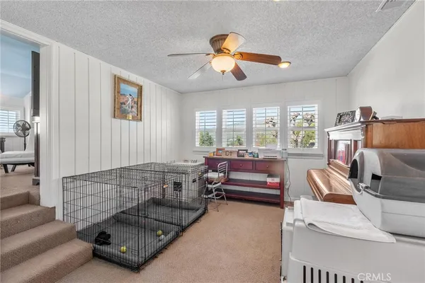 a bedroom with a bed couches chair and a large window