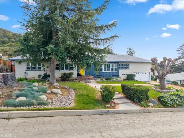 a living room with furniture a flat screen tv and a kitchen