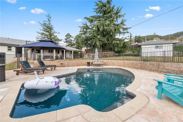 a swimming pool with trees in the background