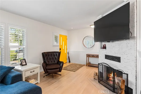 a living room with stainless steel appliances furniture and a flat screen tv