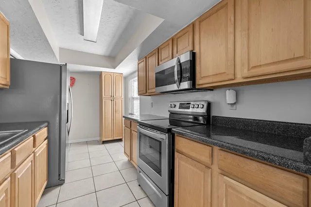 a kitchen with stainless steel appliances granite countertop a stove a sink and a microwave