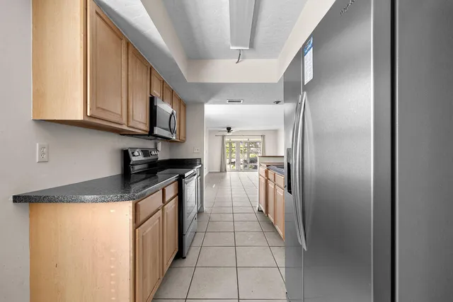 a kitchen with stainless steel appliances granite countertop a refrigerator and a stove