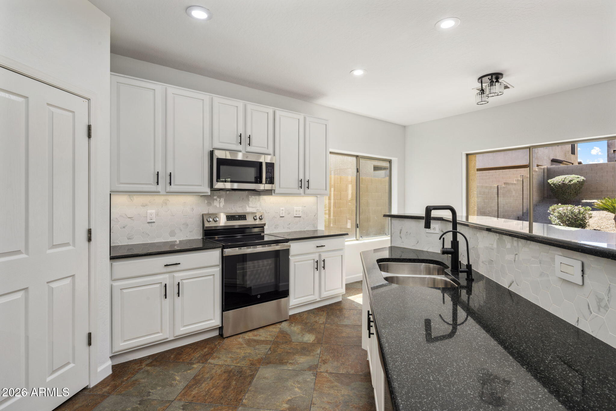 5121 West Beverly Road Laveen, AZ 85339 - Photo 18 of 32 a kitchen with granite countertop white cabinets and stainless steel appliances