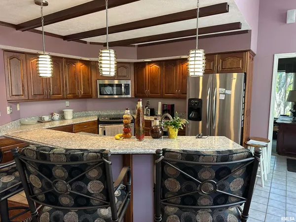 a kitchen with kitchen island granite countertop a sink and cabinets