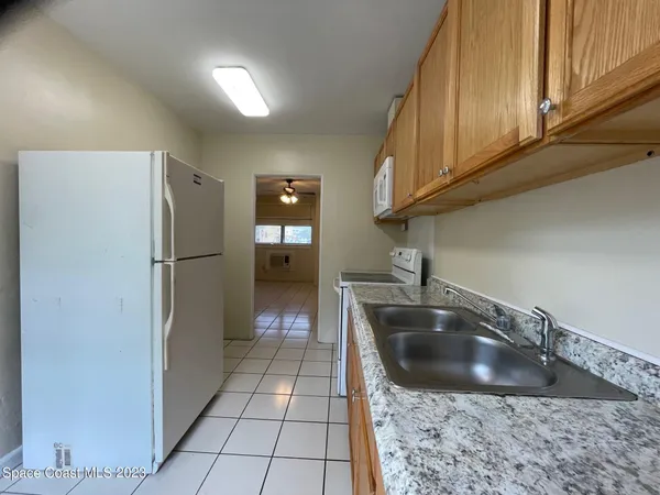 a kitchen with a sink a refrigerator and cabinets