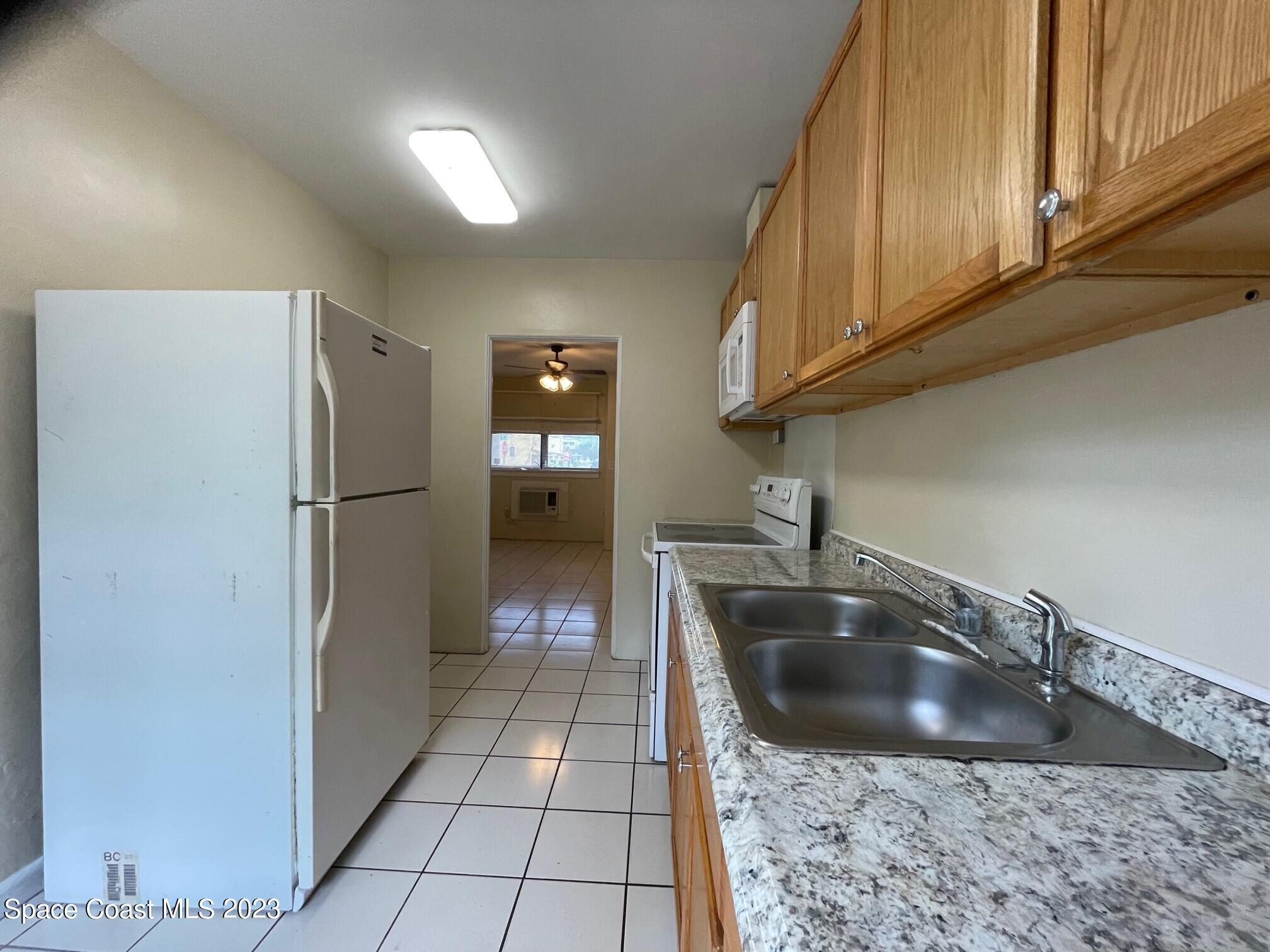 102 Center Street, Unit 102 Cocoa, FL 32922 - Photo 4 of 12 a kitchen with a sink a refrigerator and cabinets