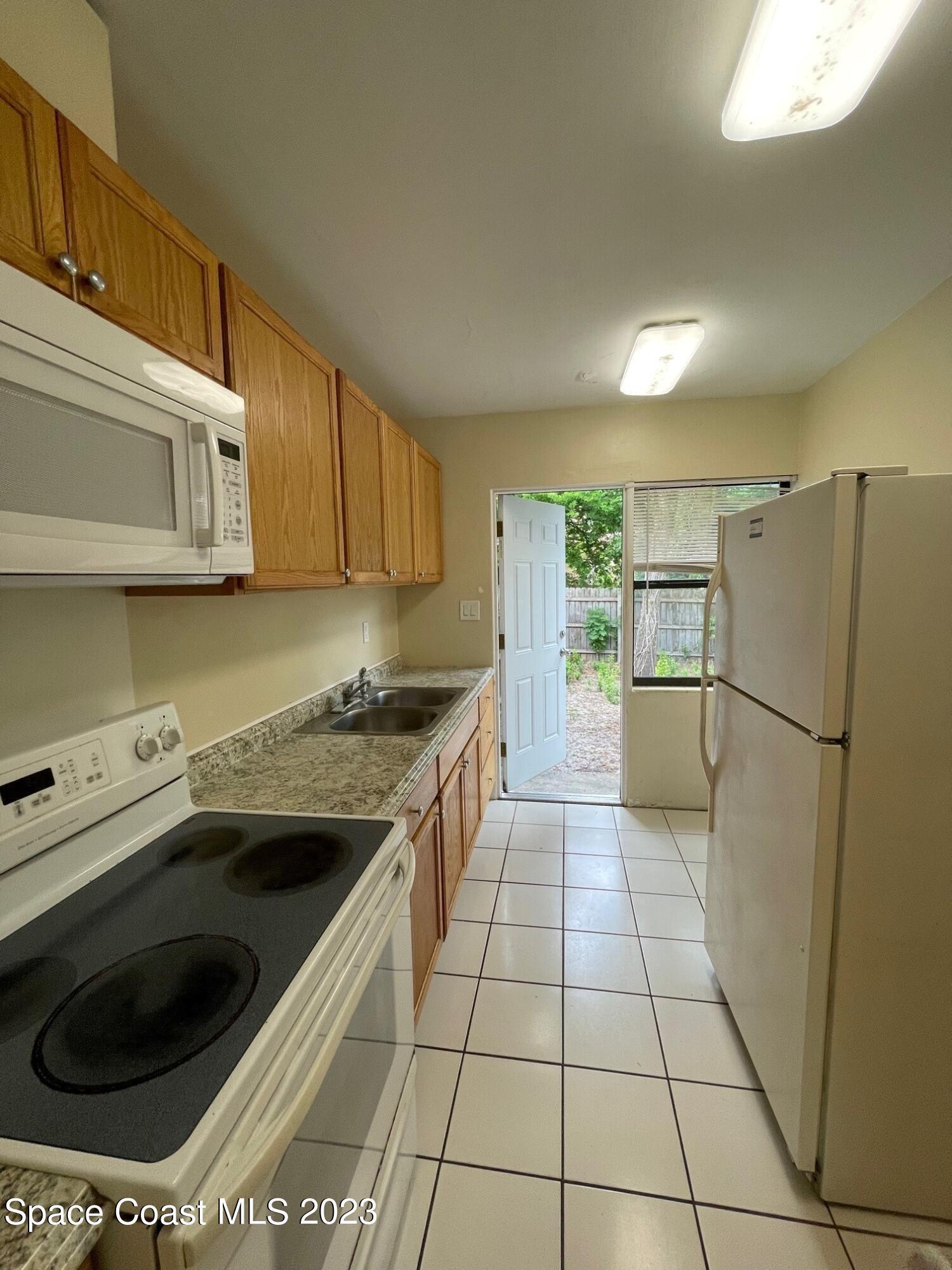 102 Center Street, Unit 102 Cocoa, FL 32922 - Photo 5 of 12 a kitchen with a cabinets and white appliances