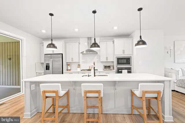 a kitchen with kitchen island granite countertop a sink a center island and appliances