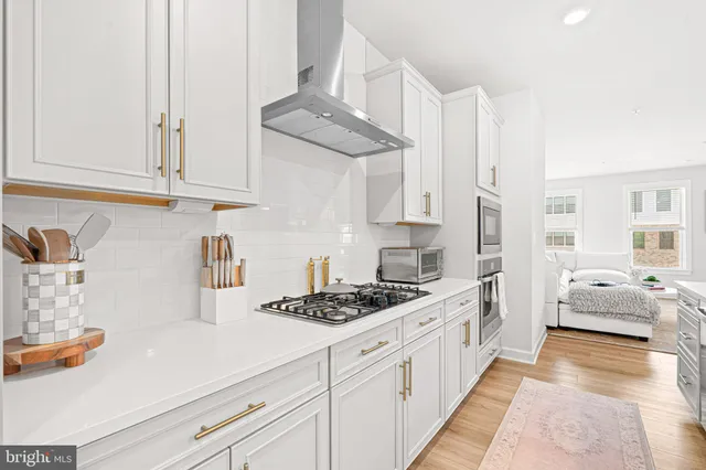 a kitchen with stainless steel appliances granite countertop a sink stove and cabinets
