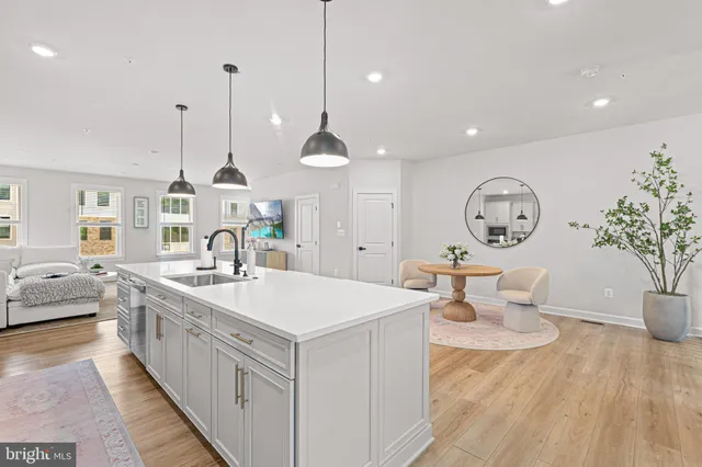 a large room with chandelier fan and a wooden floor