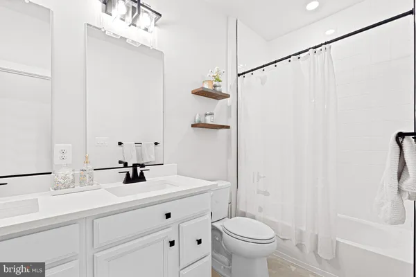 a bathroom with a sink a toilet a mirror and shower