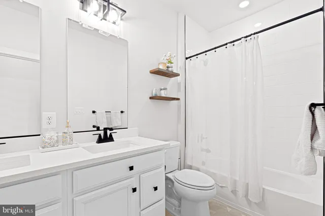 a bathroom with a sink a toilet a mirror and shower