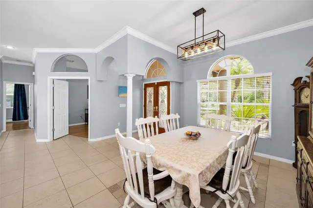 a kitchen with a table chairs and flat screen tv
