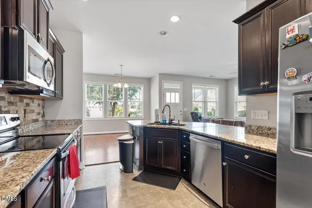 a kitchen with granite countertop a sink stainless steel appliances and cabinets