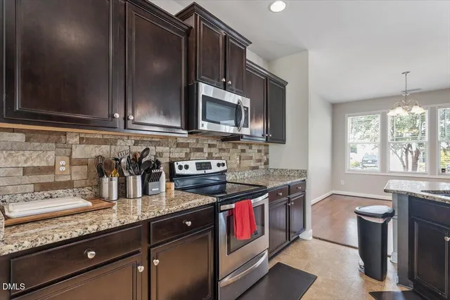 a kitchen with granite countertop a sink stove and cabinets