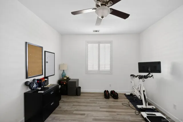 a view of a livingroom with wooden floor and a ceiling fan